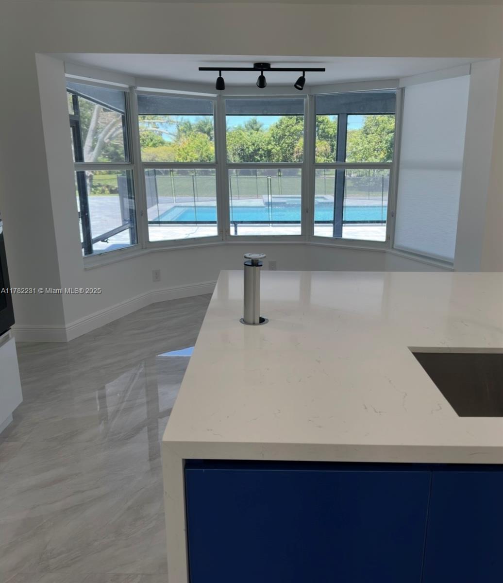 16911 Southwest 66th Street Southwest Ranches, FL 33331 - Photo 28 of 70 a kitchen with a sink a large window and a refrigerator