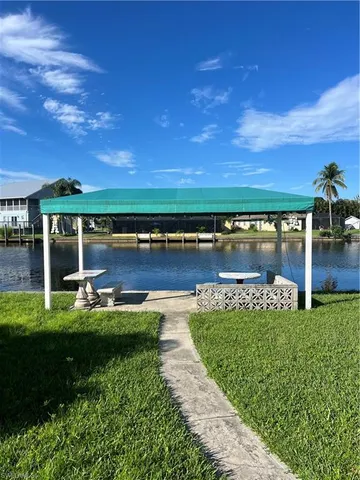 a view of a swimming pool with lawn chairs and a floor to ceiling window