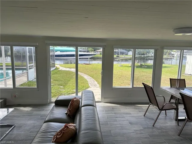 a living room with furniture and floor to ceiling windows