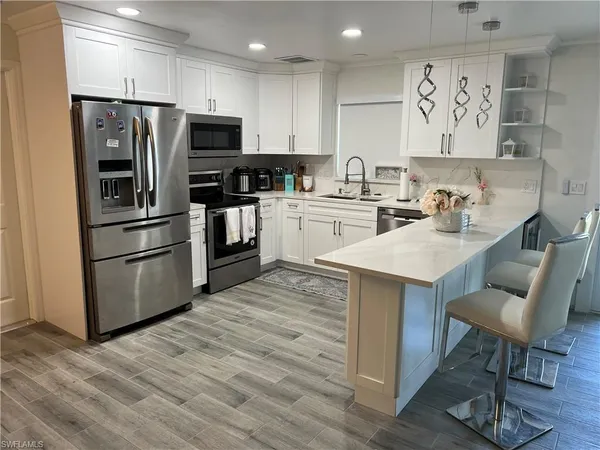 a kitchen with granite countertop a refrigerator stove and microwave