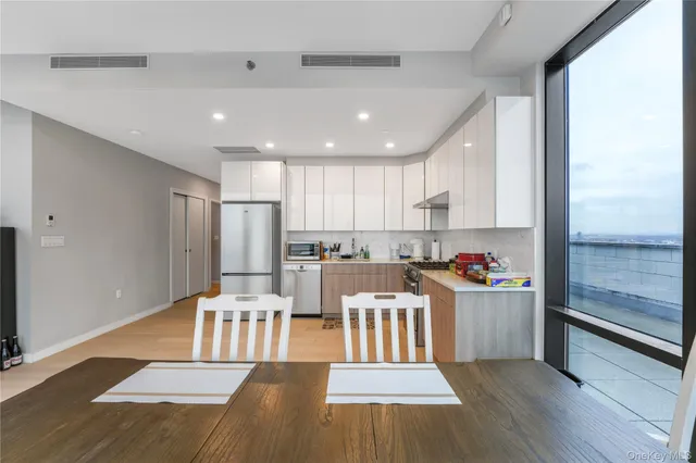 a living room with stainless steel appliances kitchen island granite countertop wooden floor a dining table and chairs