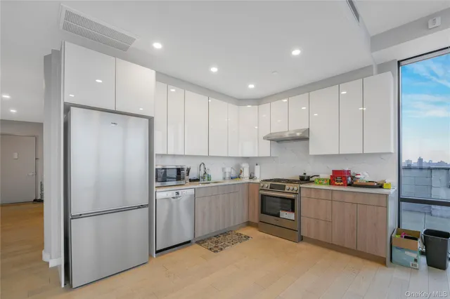 a kitchen with a sink a refrigerator and cabinets