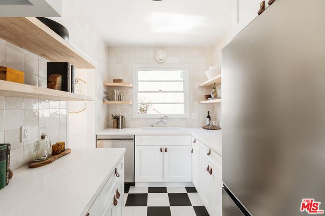 a kitchen with a sink a stove a refrigerator and cabinets