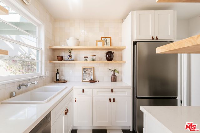 a kitchen with stainless steel appliances a refrigerator and a sink