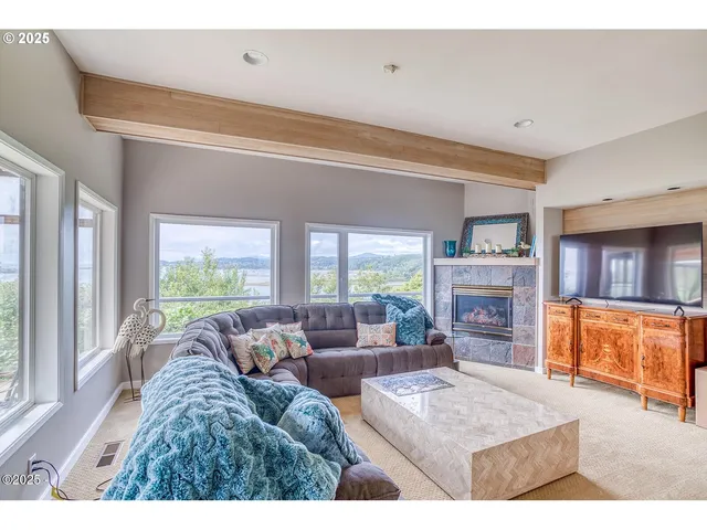 a living room with furniture fireplace and a large window