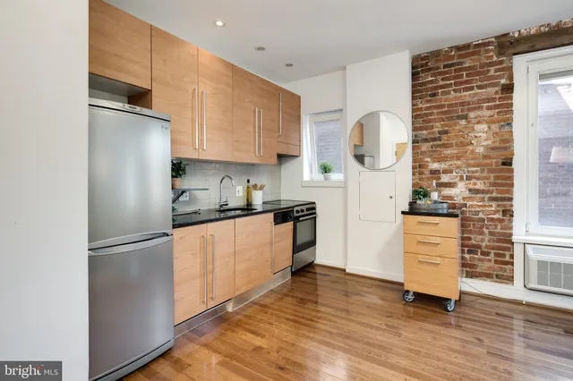 a kitchen with granite countertop wooden floors and stainless steel appliances