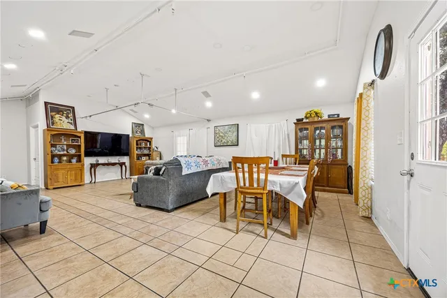 a living room with furniture a flat screen tv and kitchen view