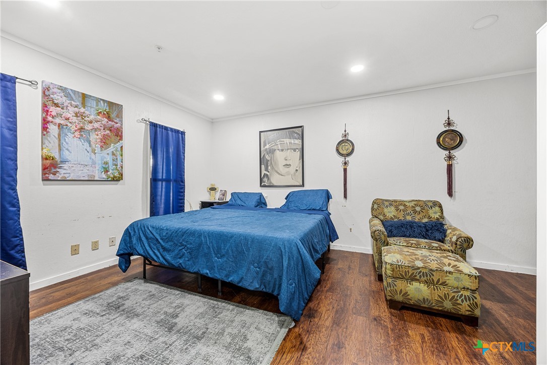 15309 Delahunty Lane Pflugerville, TX 78660 - Photo 15 of 35 a bedroom with furniture and wooden floor