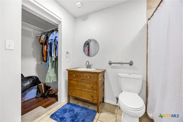 a bathroom with a toilet a sink and a mirror