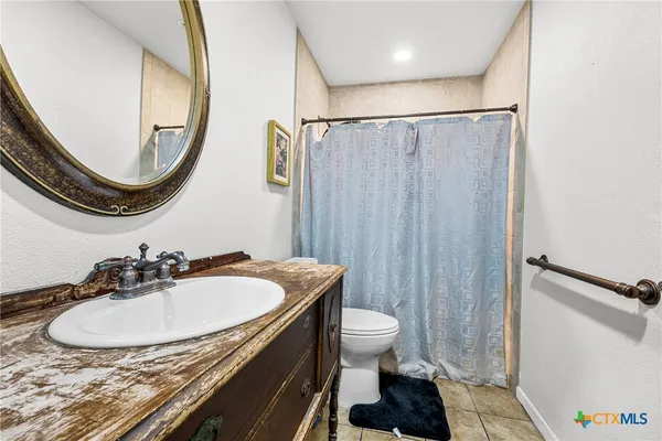 a bathroom with a sink a toilet and a mirror