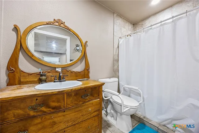 a bathroom with a sink mirror vanity and toilet