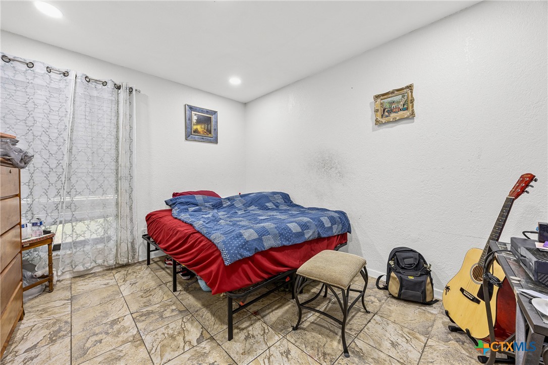 15309 Delahunty Lane Pflugerville, TX 78660 - Photo 27 of 35 a bedroom with a bed and a flat screen tv