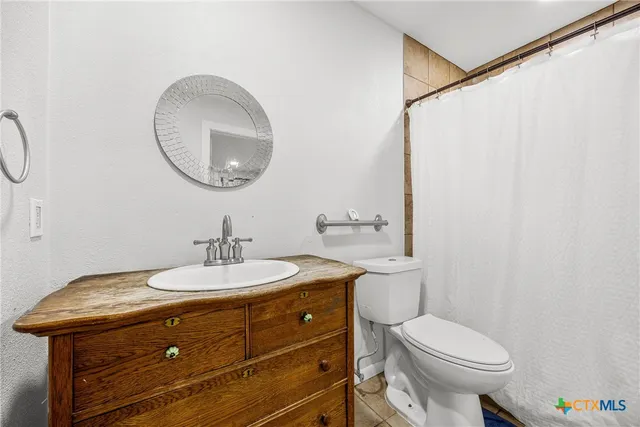 a bathroom with a toilet a sink and a mirror