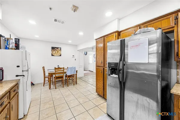 a kitchen with stainless steel appliances refrigerator and table