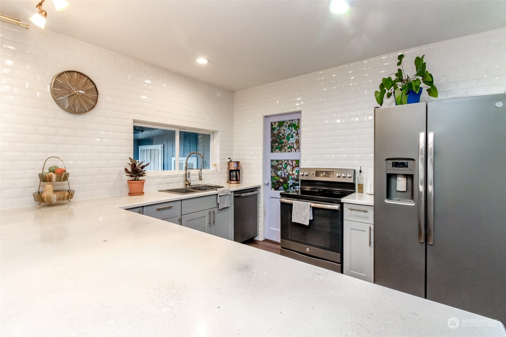 3903 Freeman Road East Edgewood, WA 98371 - Photo 17 of 40 a kitchen with granite countertop a refrigerator a stove a sink and a dining table