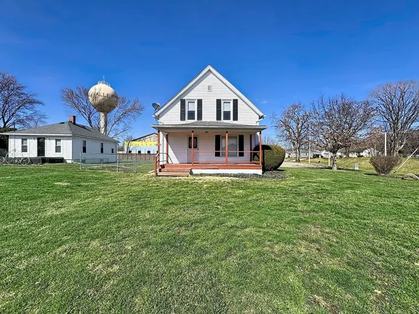 a view of a house with a big yard and large trees