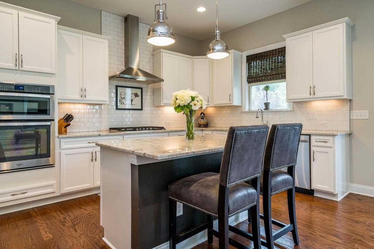 5268 Aleppo Lane Raleigh, NC 27613 - Photo 6 of 30 Quartz counters, subway tile backsplash, stainless appliances, sleek hood and kitchen island---perfect for entertaining and everyday meals! Kitchen
