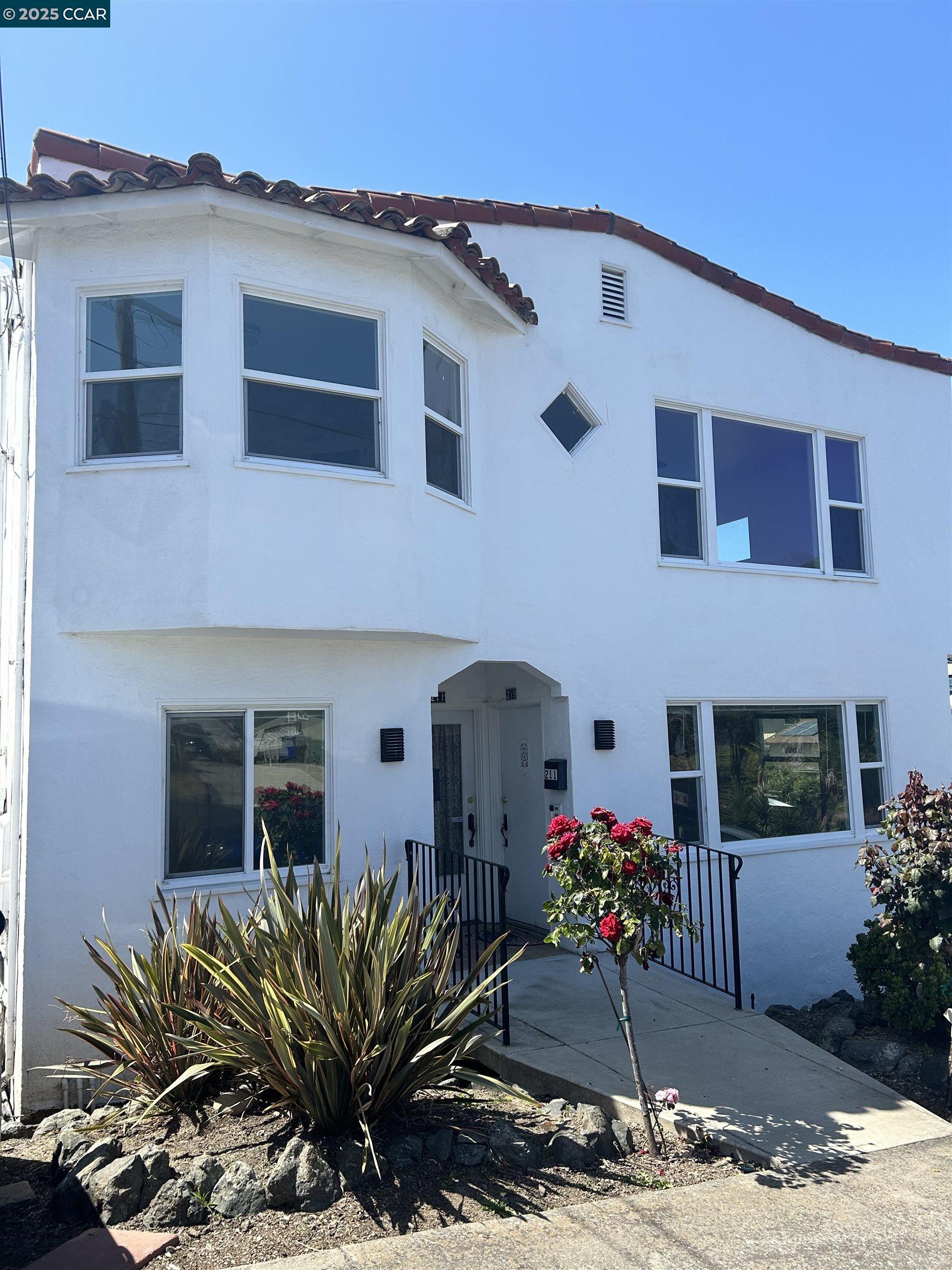 a front view of a house with a lot of flower plants