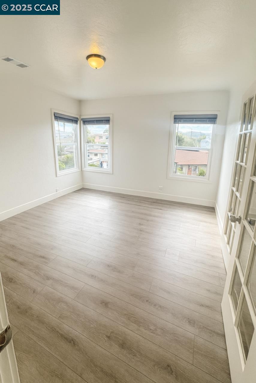 211 Second Street, Unit TOP Rodeo, CA 94572 - Photo 9 of 12 wooden floor in an empty room with a window