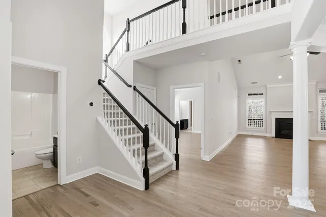 a view of a hallway with wooden floor and staircase