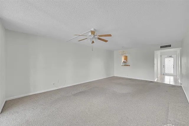 a view of an empty room with a ceiling fan