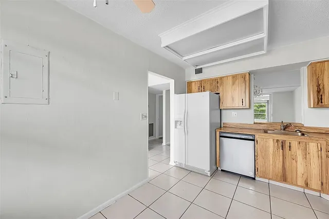 a kitchen with granite countertop a refrigerator and a stove top oven