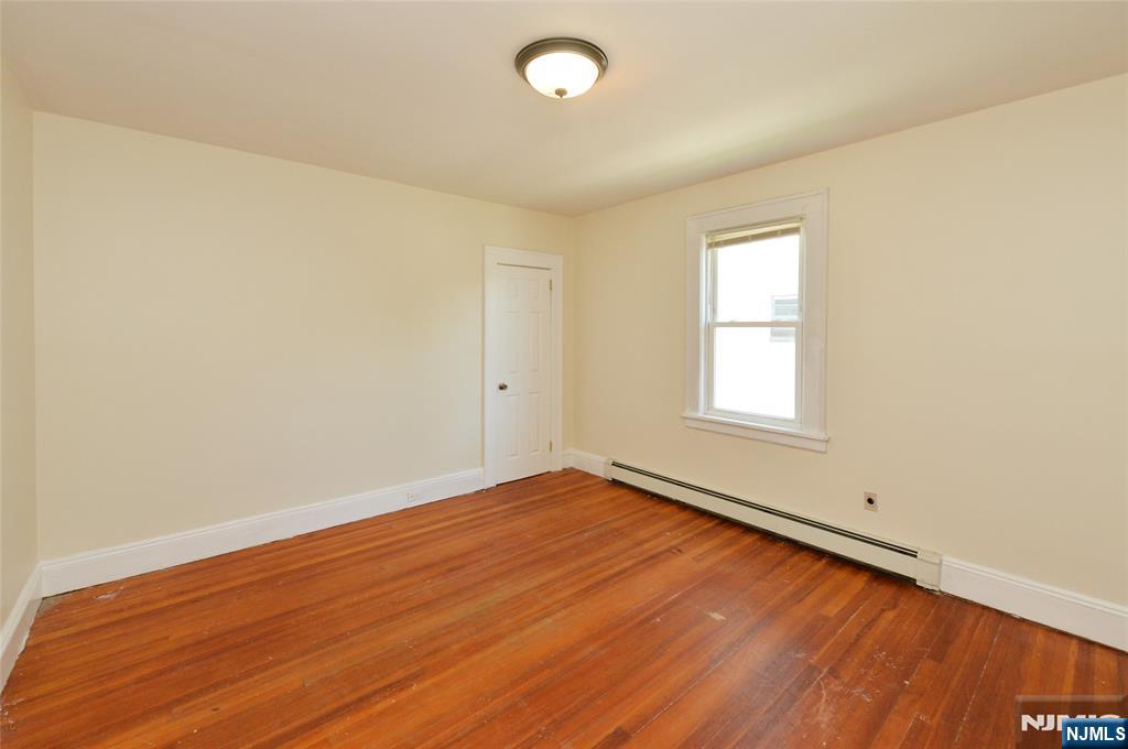 62 Broadway, Unit 1 Hackensack, NJ 07601 - Photo 11 of 25 an empty room with wooden floor and windows