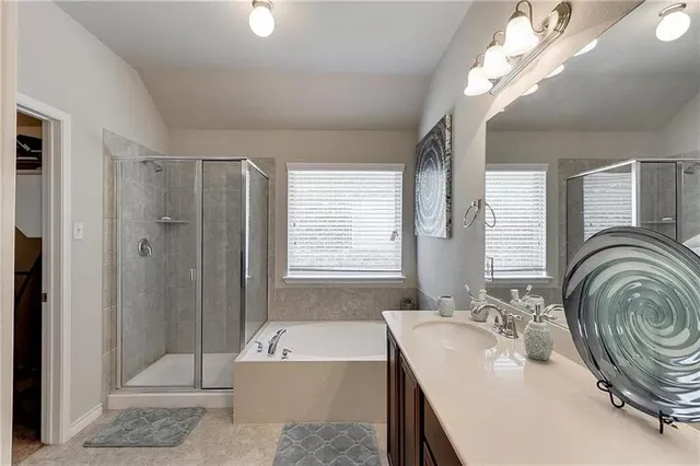a bathroom with double vanity sinks a mirror and a bathtub