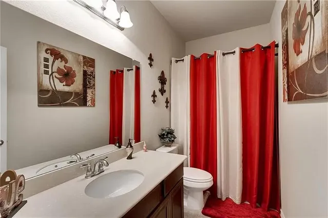 a bathroom with a sink vanity mirror and toilet