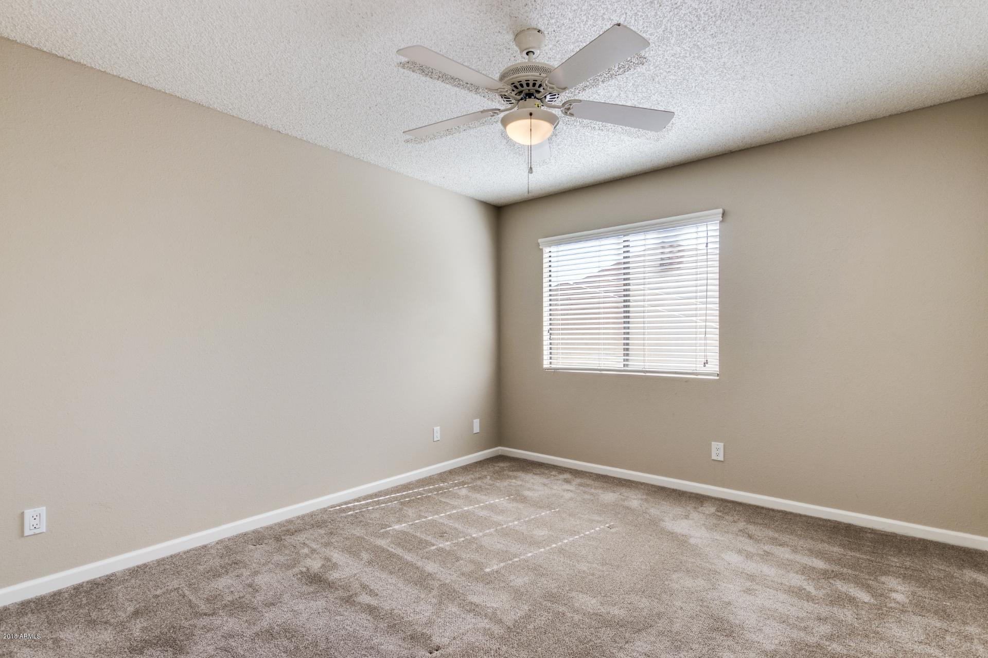 3511 East Baseline Road, Unit 1082 Phoenix, AZ 85042 - Photo 13 of 23 an empty room with windows and fan