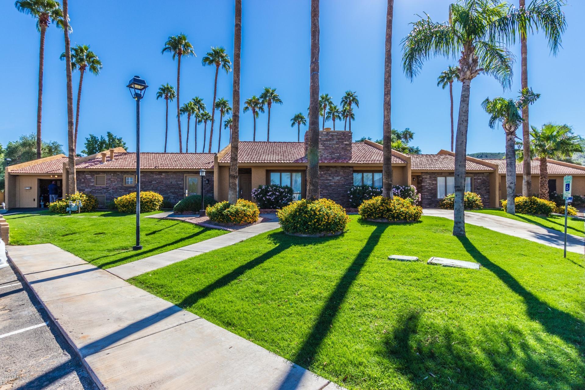 3511 East Baseline Road, Unit 1082 Phoenix, AZ 85042 - Photo 18 of 23 a view of a house with a yard and palm trees