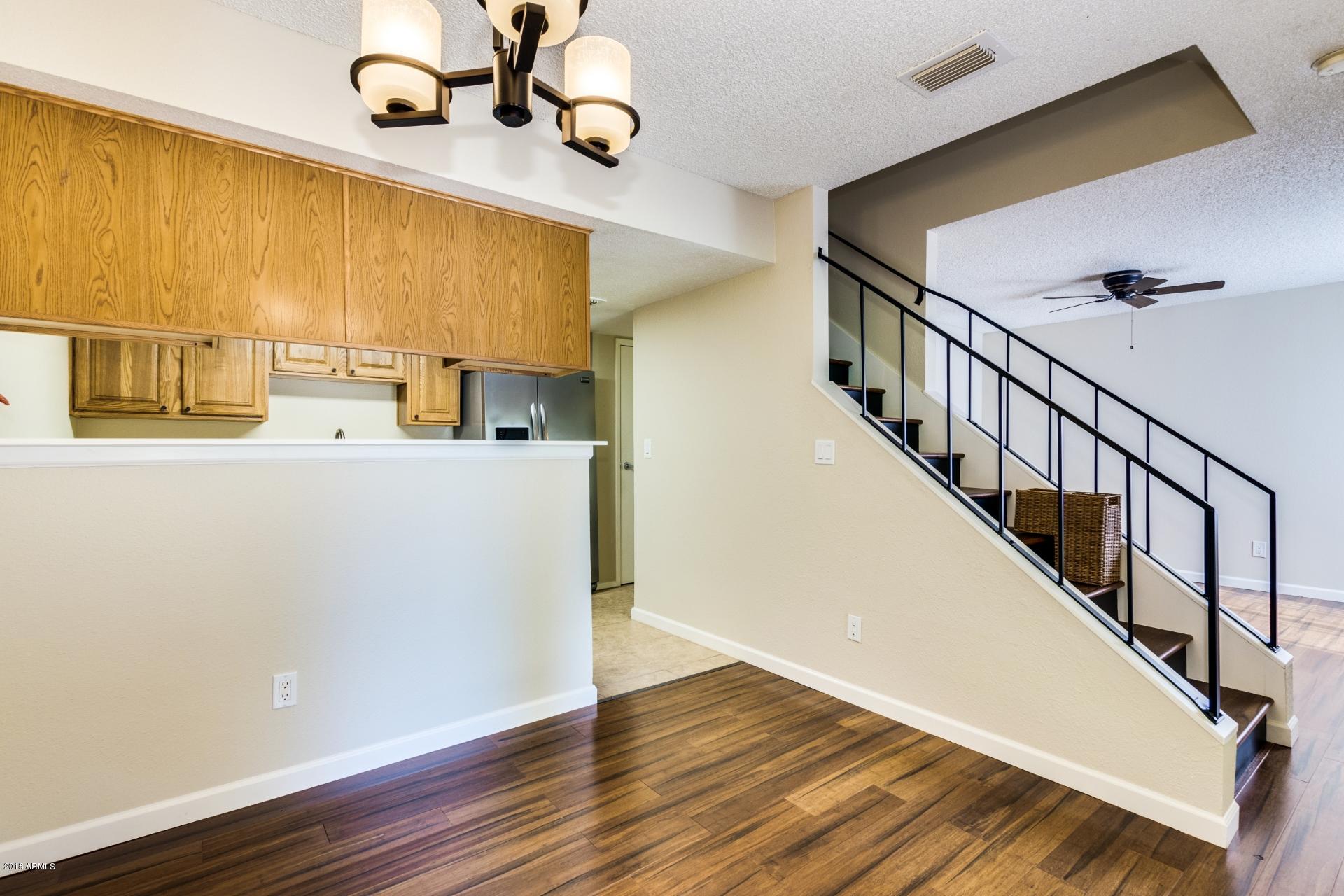 3511 East Baseline Road, Unit 1082 Phoenix, AZ 85042 - Photo 7 of 23 a view of a kitchen with wooden floor and a hallway