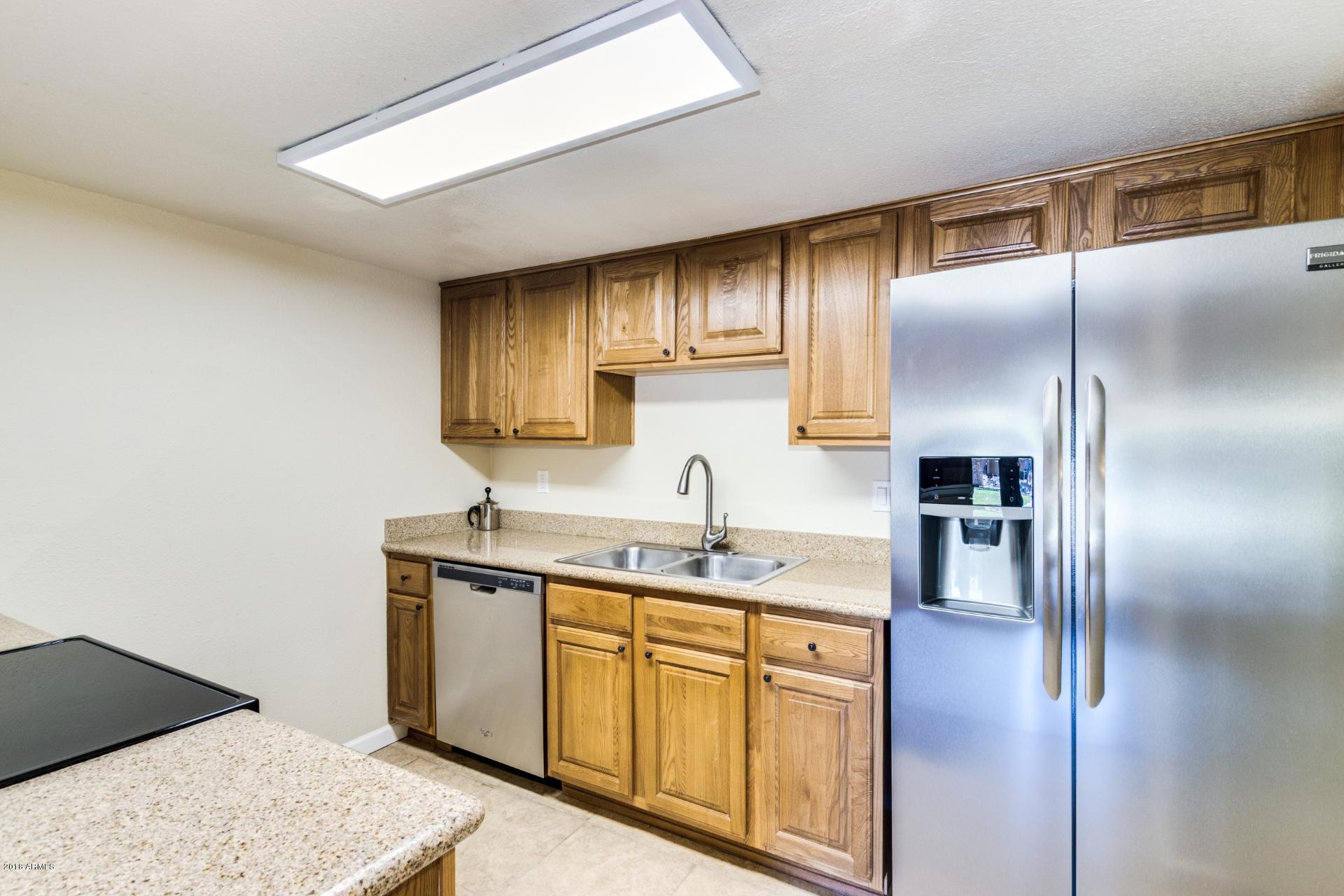 3511 East Baseline Road, Unit 1082 Phoenix, AZ 85042 - Photo 8 of 23 a kitchen with a sink a refrigerator and cabinets