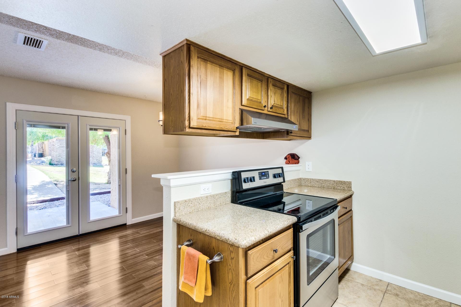 3511 East Baseline Road, Unit 1082 Phoenix, AZ 85042 - Photo 10 of 23 a kitchen with stainless steel appliances granite countertop a stove and a refrigerator