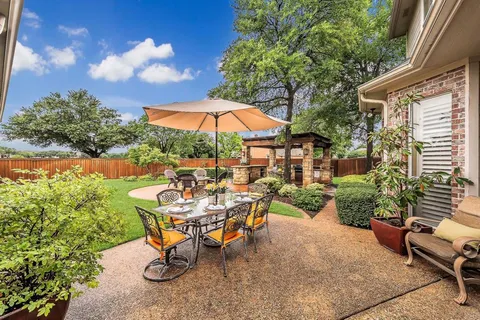 a view of a backyard with furniture and a garden