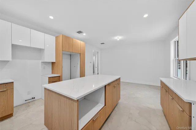 a kitchen with white cabinets a sink and a refrigerator