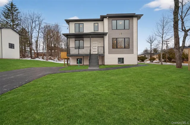 a view of a house with a big yard and large trees
