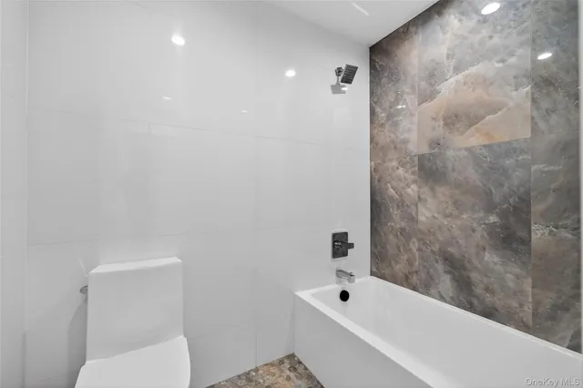 a bathroom with a toilet and bathtub