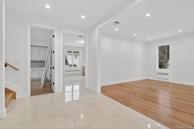 a view of a hallway with wooden floor and windows