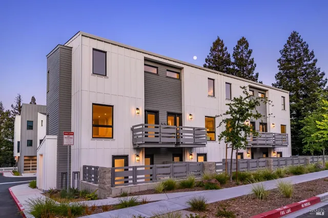 a front view of a multi story residential apartment building with yard