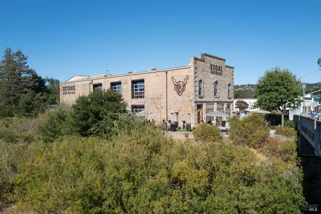 a view of a large building with a yard and large trees