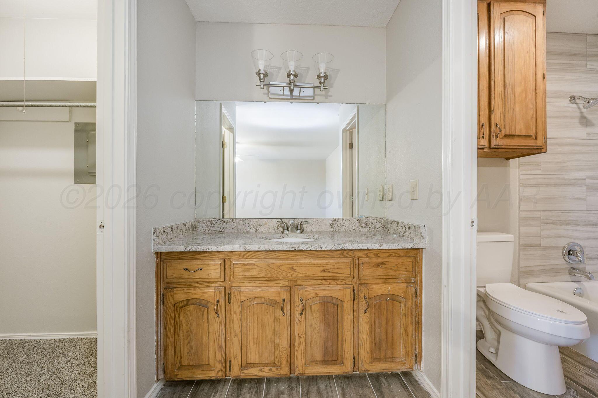6000 Hampton Drive Amarillo, TX 79109 - Photo 13 of 19 a bathroom with a granite countertop sink and a mirror