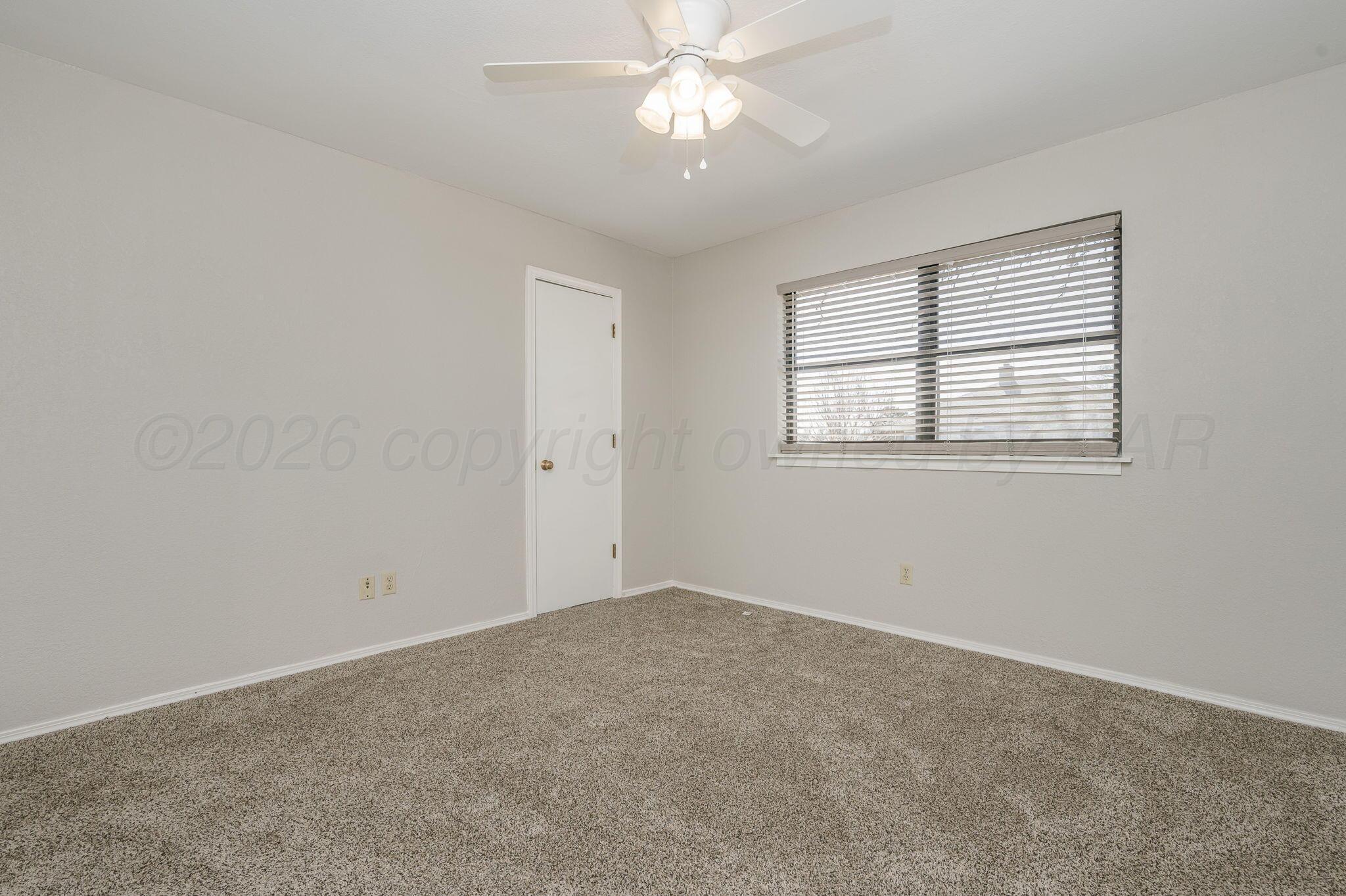 6000 Hampton Drive Amarillo, TX 79109 - Photo 14 of 19 an empty room with chandelier fan and windows