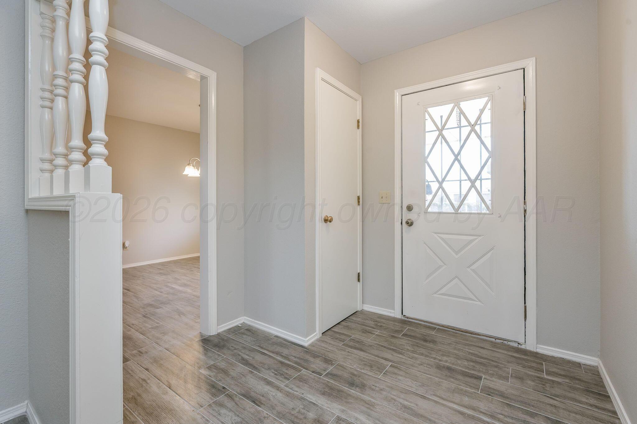6000 Hampton Drive Amarillo, TX 79109 - Photo 2 of 19 a view of an empty room with wooden floor and a window