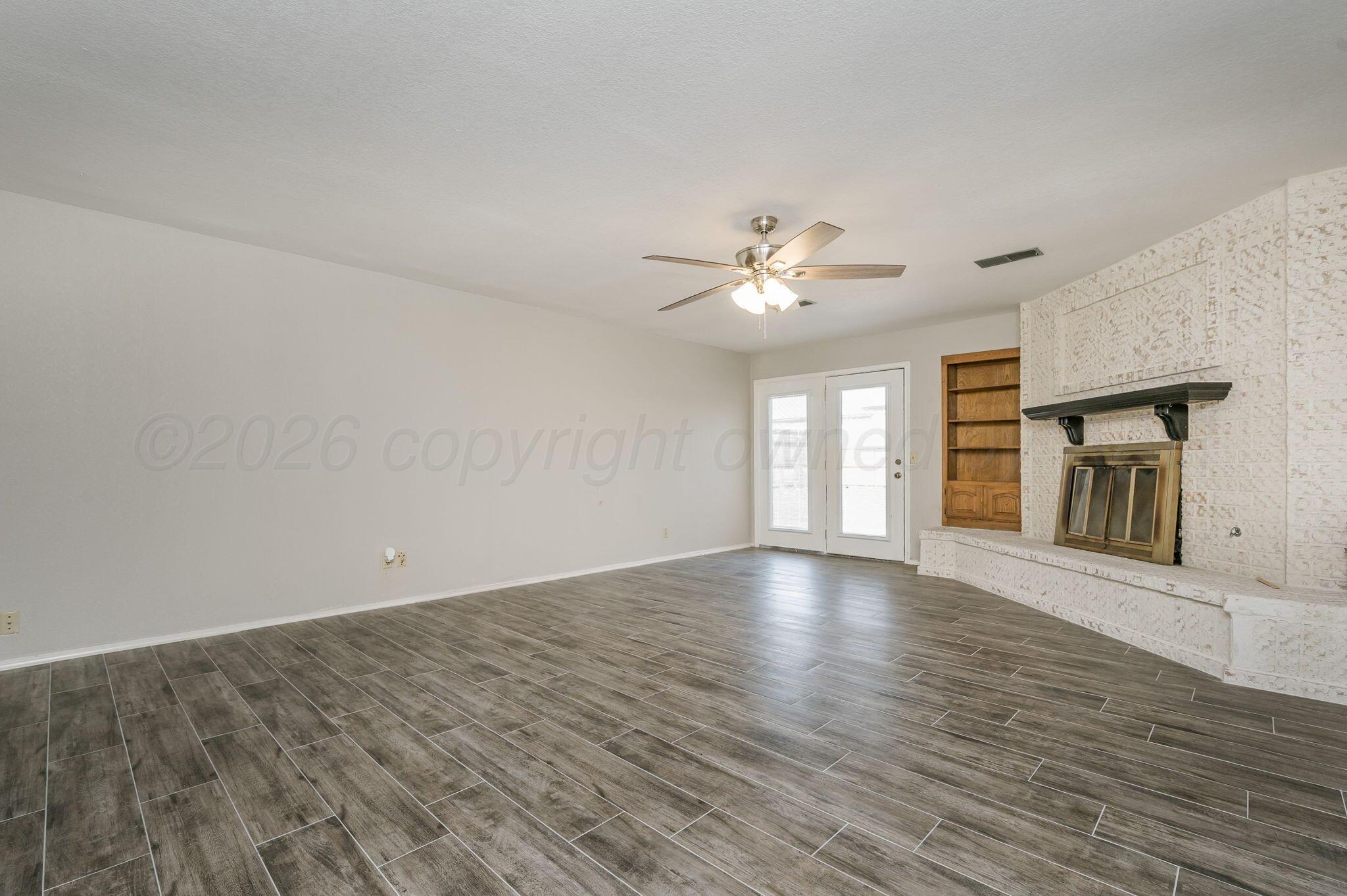 6000 Hampton Drive Amarillo, TX 79109 - Photo 4 of 19 a view of an empty room with window and wooden floor