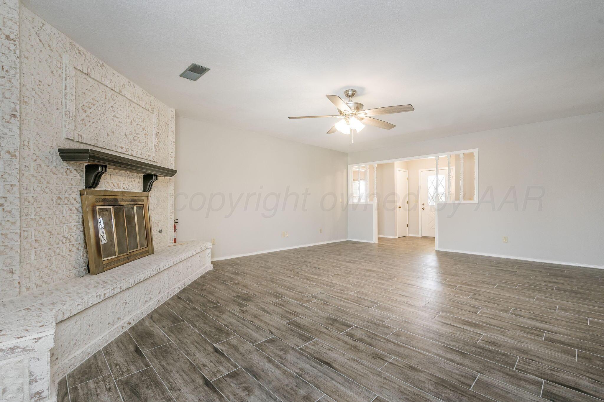 6000 Hampton Drive Amarillo, TX 79109 - Photo 5 of 19 a view of an empty room with window and wooden floor