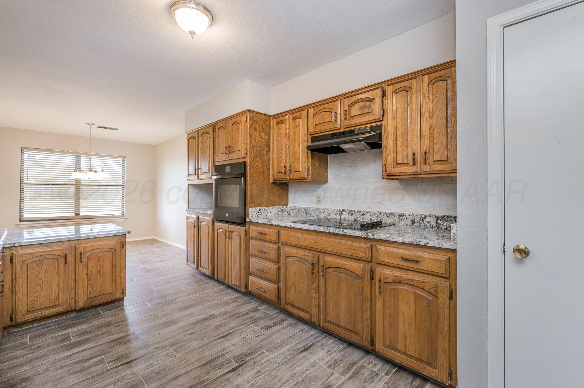 6000 Hampton Drive Amarillo, TX 79109 - Photo 7 of 19 a kitchen with stainless steel appliances granite countertop a stove a sink and a refrigerator