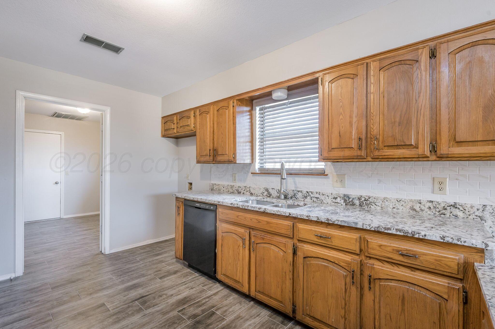 6000 Hampton Drive Amarillo, TX 79109 - Photo 8 of 19 a kitchen with stainless steel appliances granite countertop wooden cabinets a sink and dishwasher