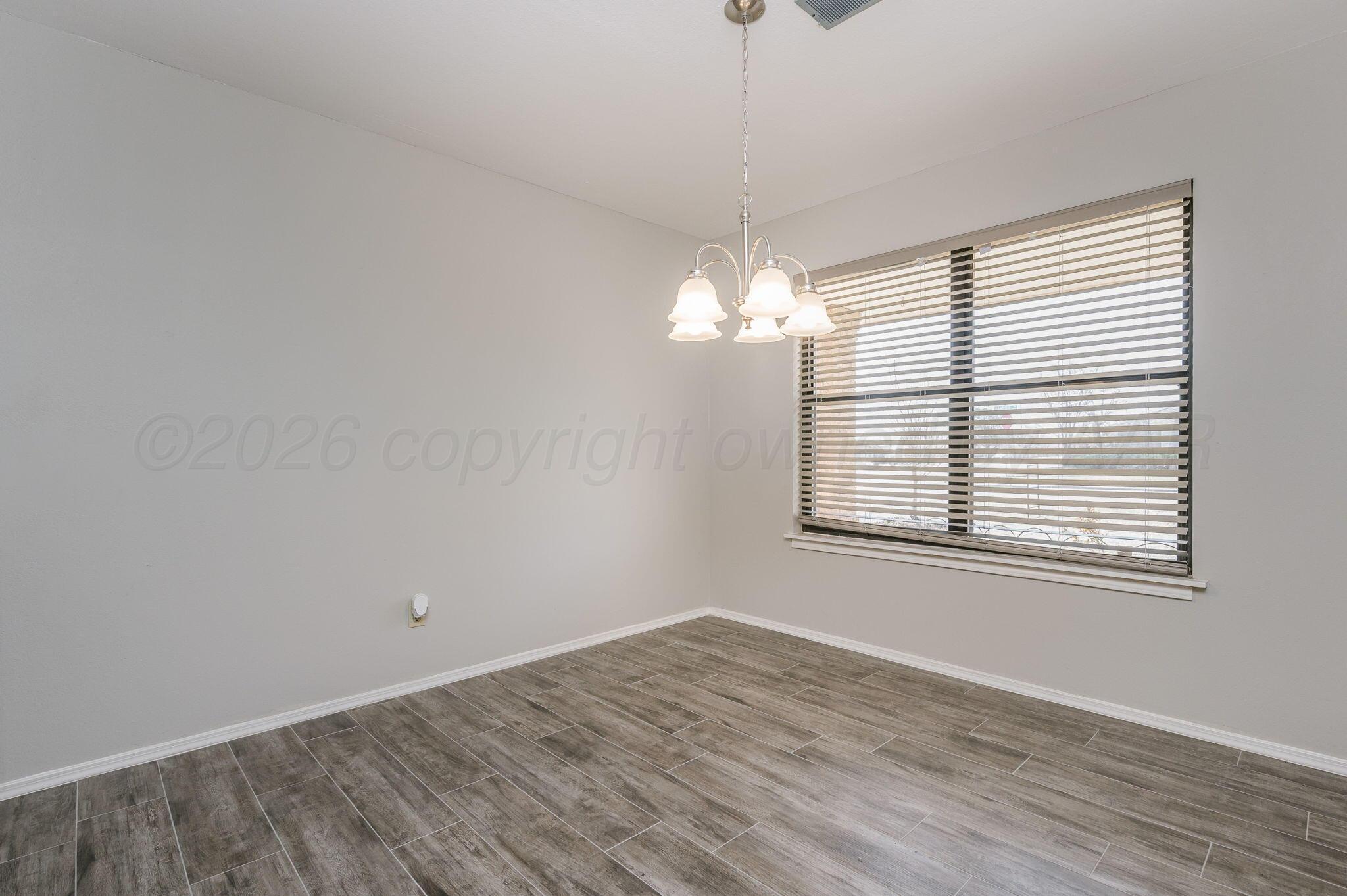 6000 Hampton Drive Amarillo, TX 79109 - Photo 9 of 19 wooden floor in an empty room with a window