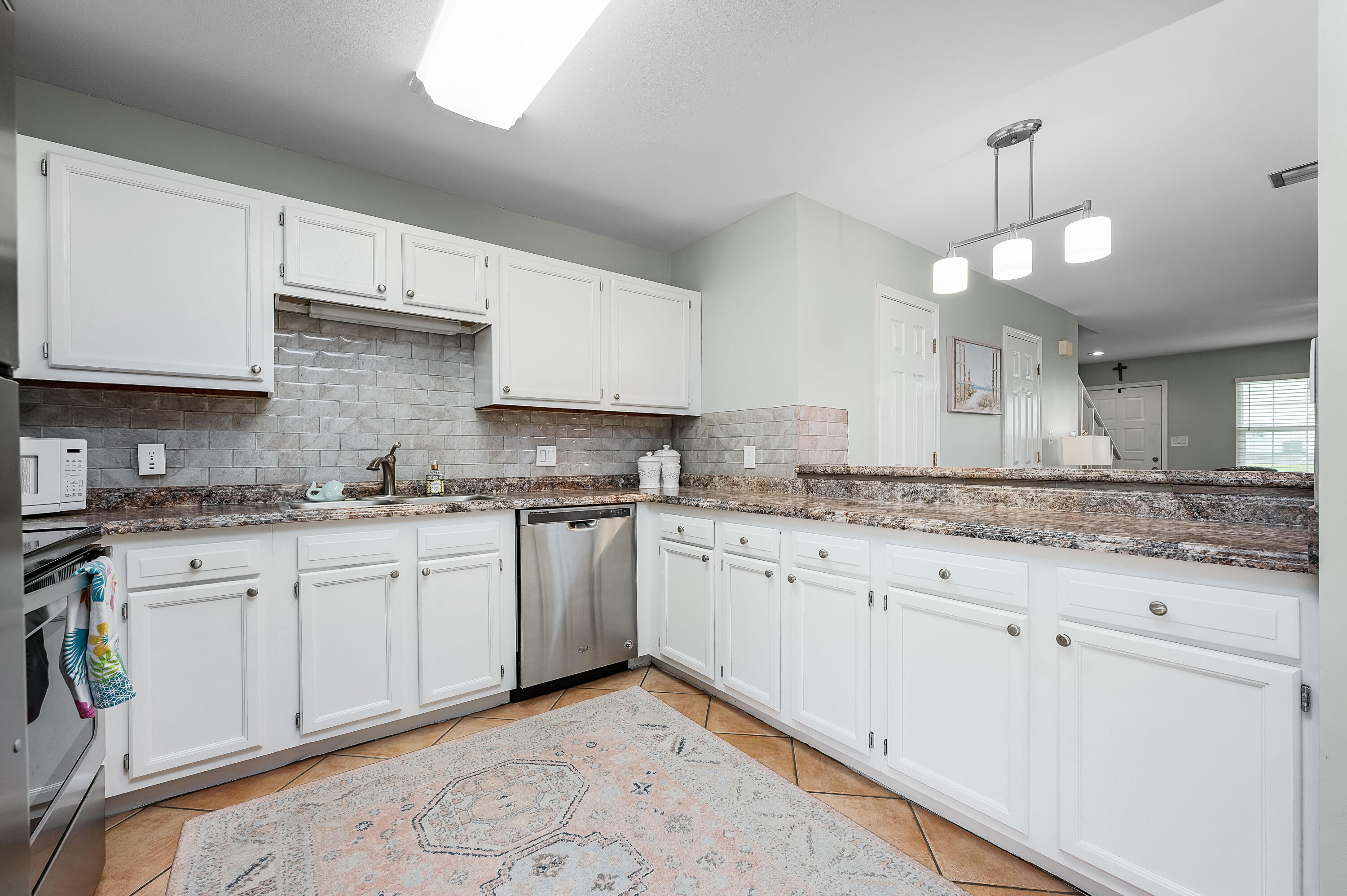 241 Ellis Road, Unit 43 Miramar Beach, FL 32550 - Photo 9 of 43 a kitchen with granite countertop white cabinets white appliances a sink and dishwasher